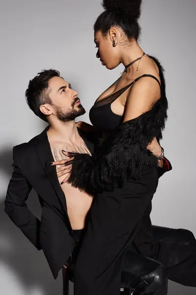 A deeply connected couple shares a tender moment while dressed in stylish clothing. — Stock Photo