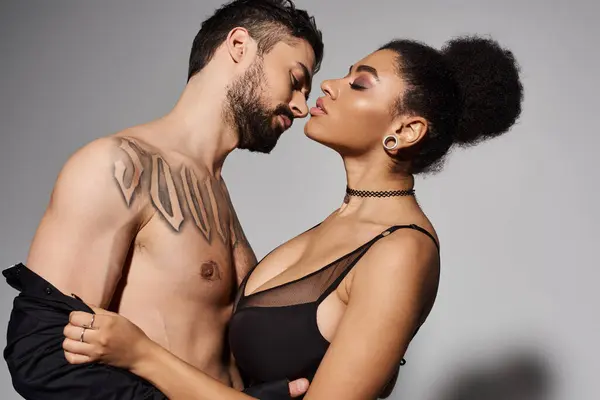 A couple leans in for a tender kiss, radiating love and attraction against a minimal backdrop. — Stock Photo