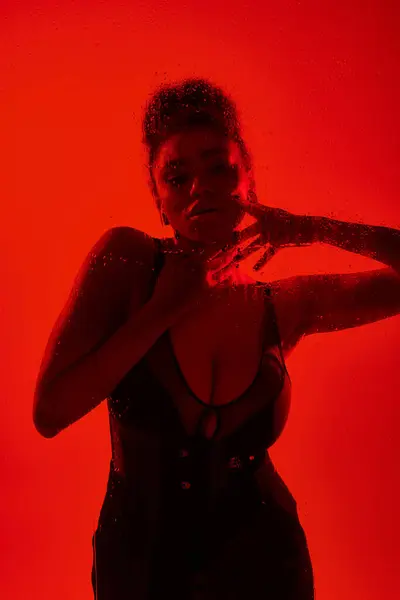 Femme séduisante en robe entourée de lumières rouges. — Photo de stock