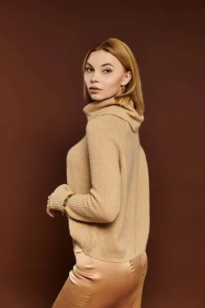 A young woman shows off her autumn style in warm earth tones against a cozy backdrop. — Stock Photo