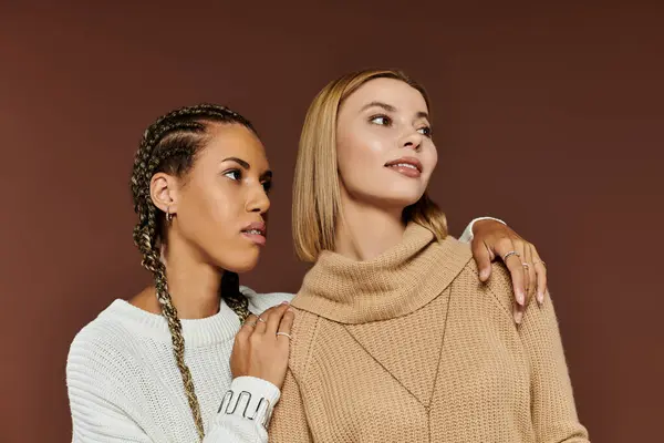 Two women in stylish sweaters share an intimate moment, radiating joy and affection during autumn. — Stock Photo