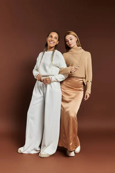 Two stylish women embrace joyfully, showcasing their autumn outfits with smiles and laughter. — Stock Photo