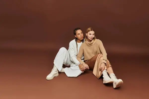 A lovely lesbian couple sits closely together, embracing warmth in cozy autumn attire. — Stock Photo
