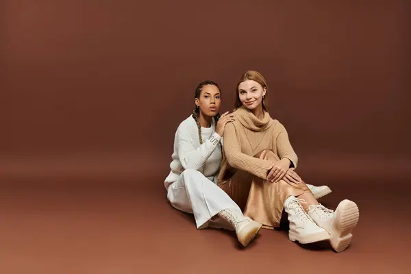 A beautiful lesbian couple embraces autumns warmth while sitting comfortably on a soft surface. — Stock Photo