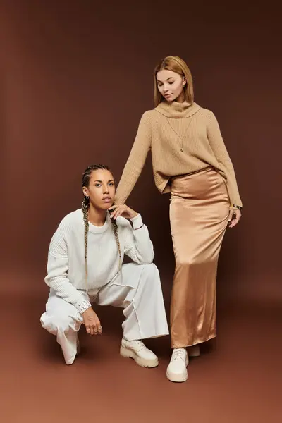 Two young women celebrate autumns beauty in stylish outfits, joyfully embracing the season. — Stock Photo
