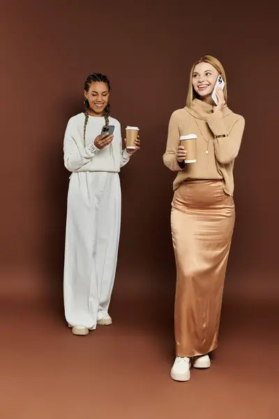 A radiant couple dressed in cozy autumn outfits happily enjoys their warm beverages while chatting. — Stock Photo