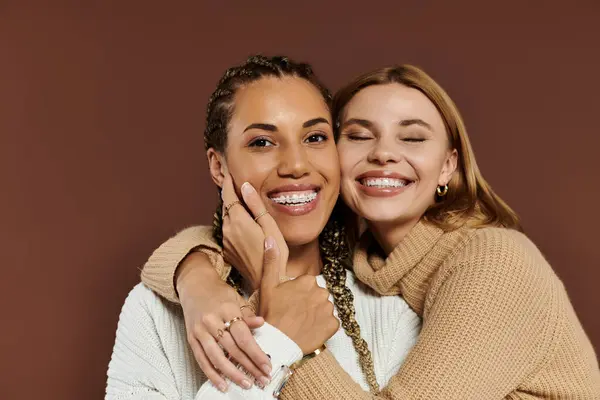 Two young women joyfully embrace, highlighting their love in autumn style. — Stock Photo