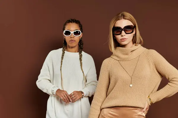 Two young women showcase their autumn attire, exuding warmth and style against a rich backdrop. — Stock Photo