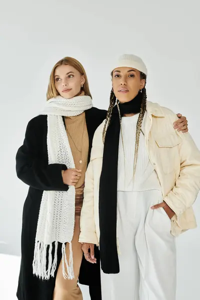 Two stylish young women share a warm moment in autumn fashion, exuding love and joy. — Stock Photo