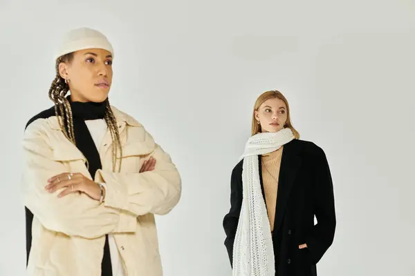 Two young women showcase their autumn outfits, radiating style and comfort in a warm atmosphere. — Stock Photo
