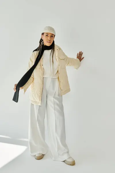 Attractive young woman in stylish warm attire posing on white backdrop. — Stock Photo
