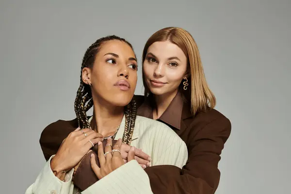 Two young women in cozy autumn clothing share a tender moment of affection and style. — Stock Photo