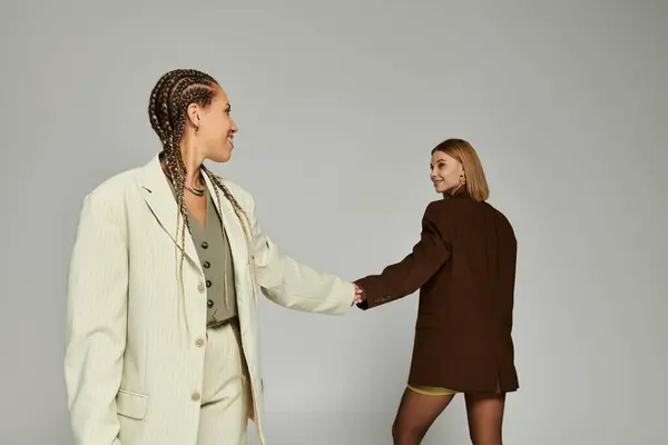 Two stylish women share a tender connection while dressed for an autumn day. — Stock Photo