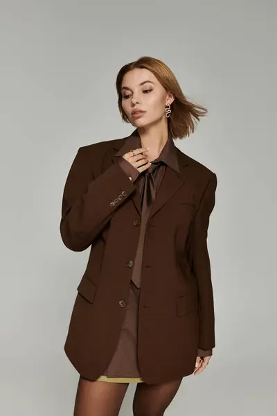 Stylish blonde woman in brown warm clothing posing actively. — Stock Photo