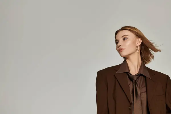 Sophisticated blonde woman in brown warm clothing posing actively. — Stock Photo