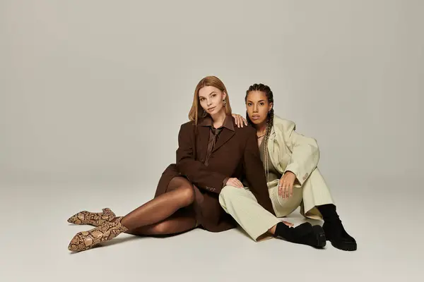 Two young women showcase autumn trends, embracing each others warmth with joy and style. — Stock Photo