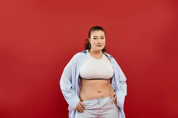 A young, beautiful plus size woman showcases her bold makeup while striking a pose in a studio setting. — Stock Photo