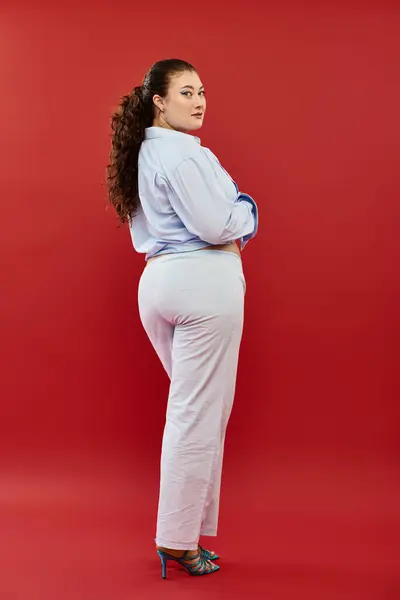 A stunning young plus size woman showcases her beauty in vivid makeup while posing elegantly in a studio. — Stock Photo