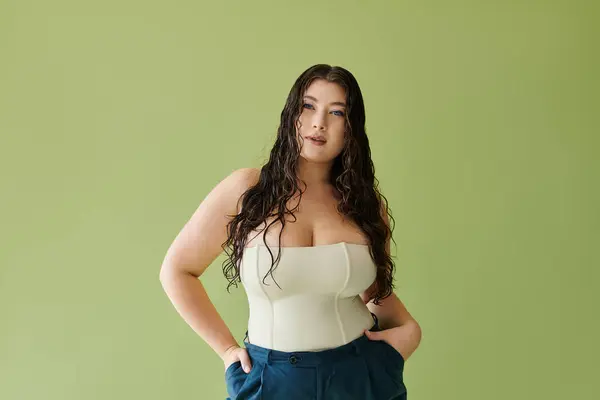 Eine junge, schöne Plus-Size-Frau mit lockigem Haar zeigt ihr Selbstvertrauen, während sie ein stylisches Korsett trägt. — Stockfoto