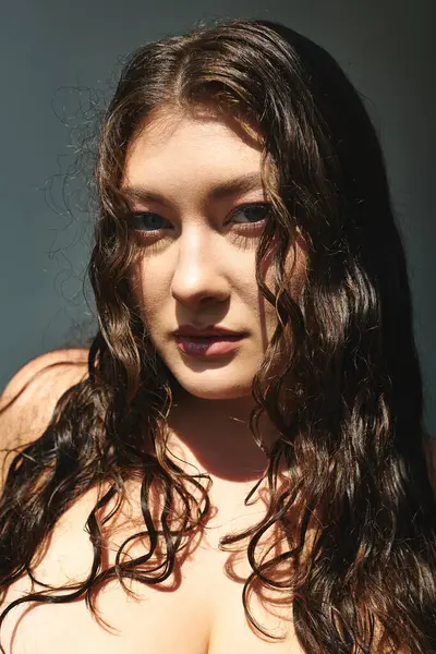 Una splendida donna plus size con i capelli ricci mostra eleganza, irradiando fiducia nello studio. — Foto stock