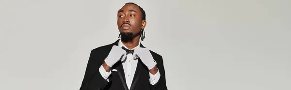 A stylish young African American man dressed in a sharp suit and vest exudes confidence, showcasing elegance. — Stock Photo