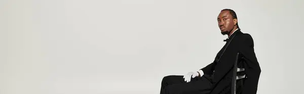 A stylish young African American man poses confidently in a formal suit, showcasing modern elegance and charm. — Stock Photo