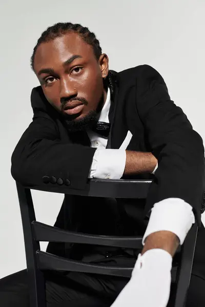 Un jeune homme afro-américain élégant fait preuve de confiance dans un costume, exsudant charme et sophistication. — Photo de stock