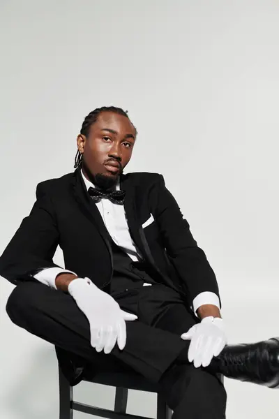 A young man dressed in a sharp suit and vest leans back elegantly, exuding confidence and charm. — Stock Photo