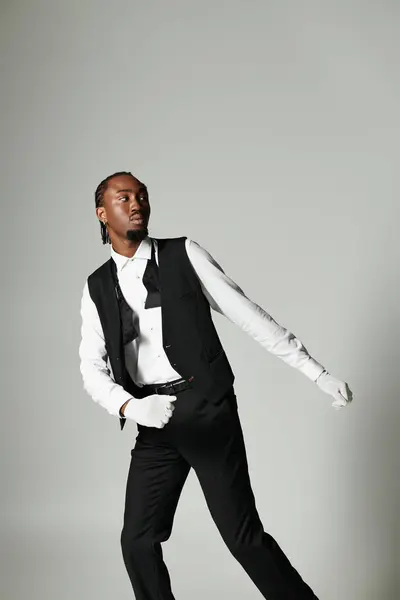 A well-dressed young man strikes a fashionable pose in a tailored suit and vest, showcasing elegance. — Stock Photo