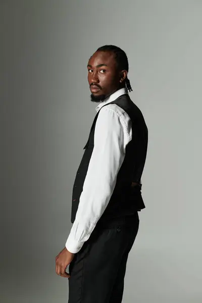 A young African American man stands elegantly in a suit, showcasing his vibrant style and confidence. — Stock Photo