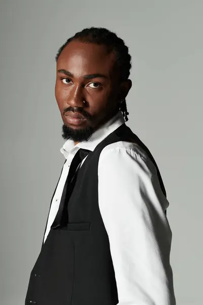 A young man in a sharp suit stands with confidence, showcasing elegance and style against a neutral backdrop. — Stock Photo