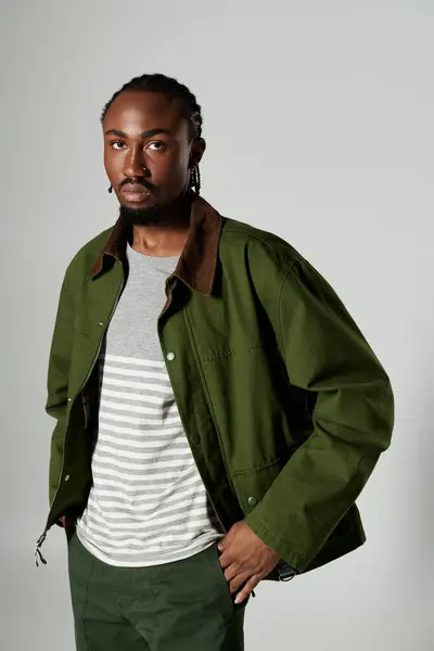 Ein junger afroamerikanischer Mann präsentiert sein modisches Flair in einem auffallend grünen Outfit, das Stil und Attitüde ausstrahlt. — Stockfoto