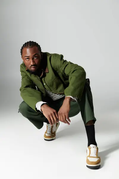 Un joven afroamericano muestra su sentido de la moda en un llamativo conjunto verde, exudando confianza. - foto de stock