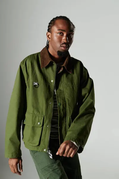Un joven afroamericano de moda posa con confianza en un llamativo conjunto verde, mostrando estilo. - foto de stock