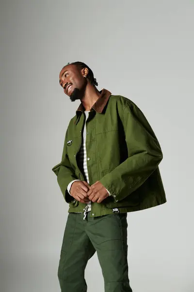 A young African American man showcases his unique green outfit while striking a playful pose. — Stock Photo