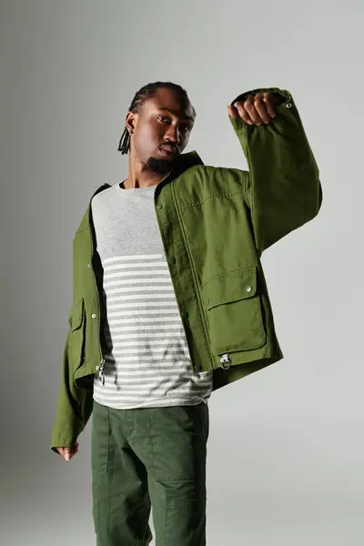 Un jeune homme dans un ensemble vert chic pose en toute confiance, reflétant l'esthétique de la mode contemporaine. — Photo de stock