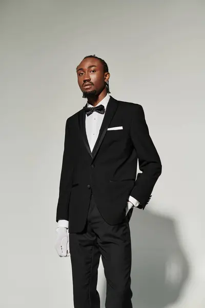 A sharply dressed young man stands confidently, showcasing his style and elegance in a formal ensemble. — Stock Photo