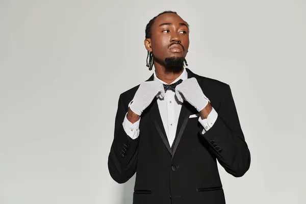 A young African American man in a sharp suit and vest exudes confidence while posing elegantly. — Stock Photo