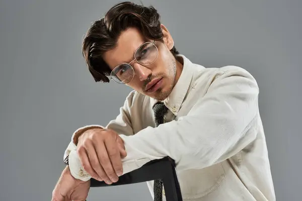 A handsome young man showcases his fashionable formal attire with a confident pose in a studio. — Stock Photo