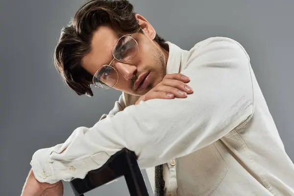 A dapper young man showcases his charm in elegant formal wear while striking a thoughtful pose indoors. — Stock Photo