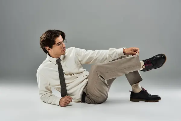 A young man in stylish formal wear strikes a confident pose, exuding charm and sophistication in a studio. — Stock Photo