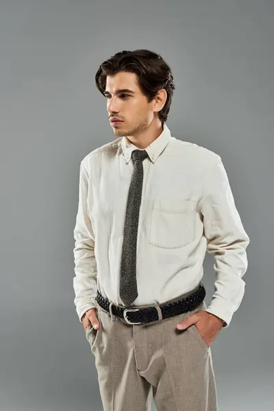 A young man in elegant attire stands confidently, showcasing his charm in a studio setting. — Stock Photo