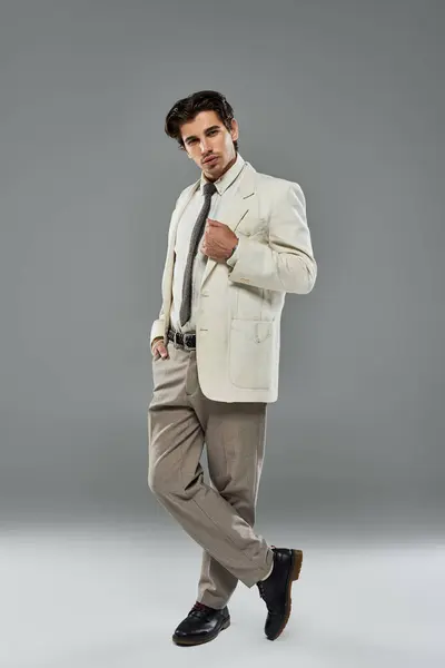 A charismatic young man dressed in elegant attire showcases his style while confidently posing in the studio. — Stock Photo