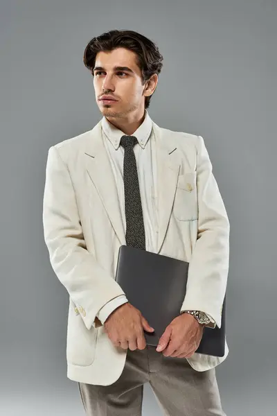 A young man dressed in elegant formalwear stands poised, conveying charisma and confidence in a studio setting. — Stock Photo