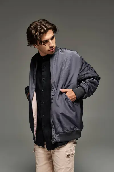 A young, handsome man confidently displays his fashionable autumn outfit, highlighting his unique style. — Stock Photo