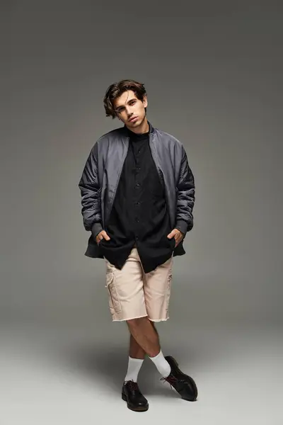 A stylish young man poses confidently in a trendy autumn outfit, exuding effortless charm and flair. — Stock Photo