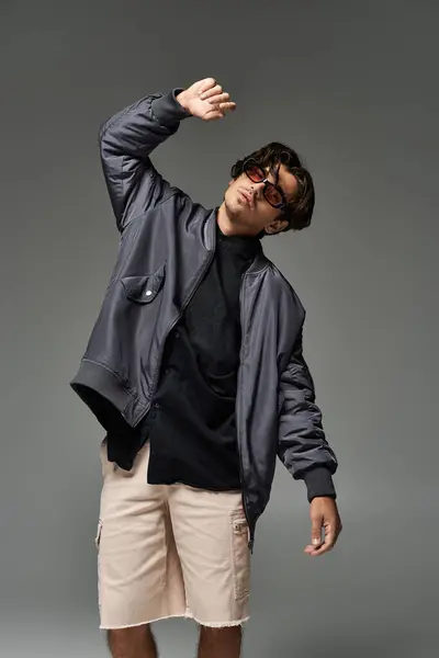 A young man confidently poses in a stylish autumn outfit, highlighting his unique fashion sense and modern flair. — Stock Photo