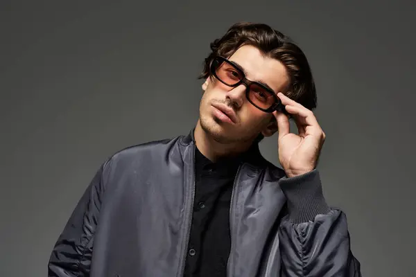 Un jeune homme dans une tenue d'automne à la mode pose avec confiance, soulignant son style moderne et son charisme. — Photo de stock