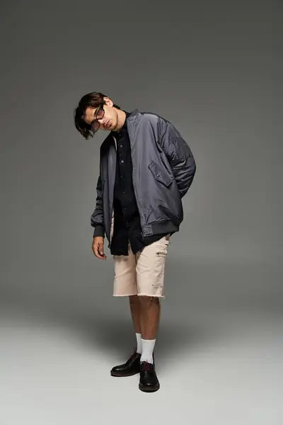 A young man showcases his fashionable autumn outfit, expressing individuality with a confident pose. — Stock Photo