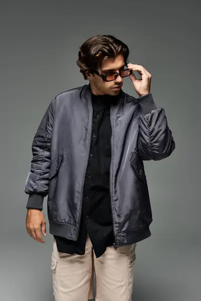 Dressed in a trendy autumn ensemble, a young man strikes a confident pose, highlighting his unique style. — Stock Photo